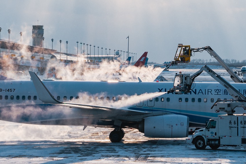 11月22日，兩台除冰車在除冰坪上給飛機大翼實施除冰作業（楊項峰攝）