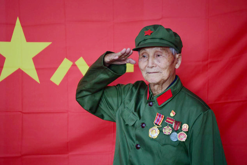 杨秀友在军旗前敬礼。（吉林省退役军人事务厅供图）