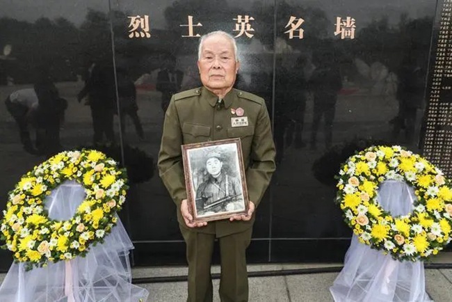 陈曾吉烈士弟弟陈虎山手捧哥哥生前照片。摘自新华网