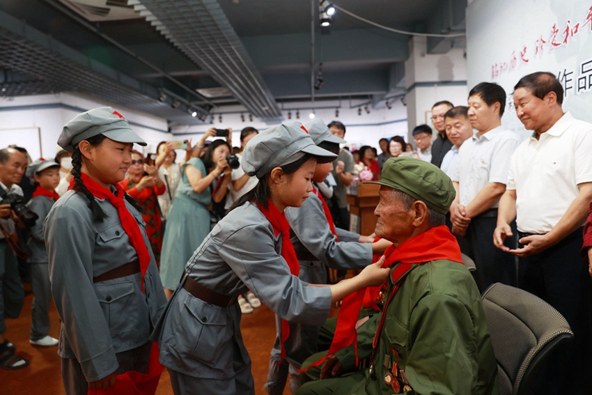 小学生代表为抗美援朝老兵戴红领巾（李军广  摄）