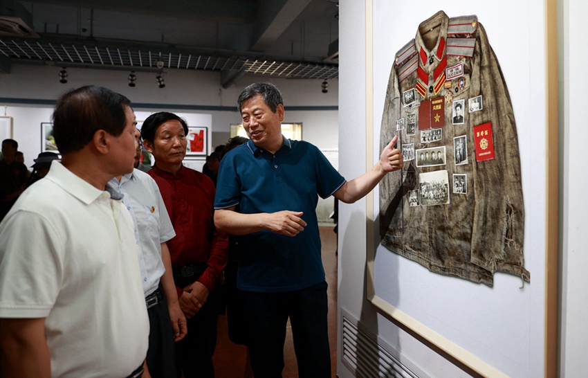 李长森向观展领导介绍照片背后的故事