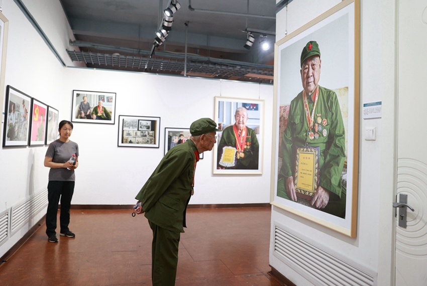 老兵在摄影展现场认真观看照片信息
