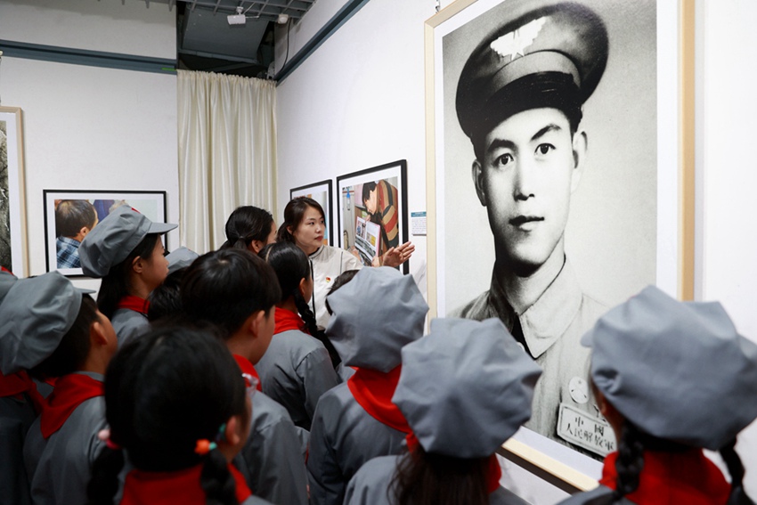 小学生在摄影展现场聆听抗美援朝故事