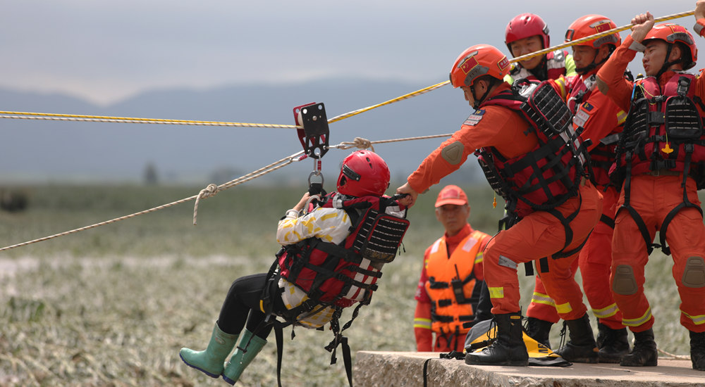 8月5日，吉林省舒兰市七里乡三合村，吉林市森林消防支队队员在利用绳索救援受困群众。孟海鹰 薛二涛摄影报道