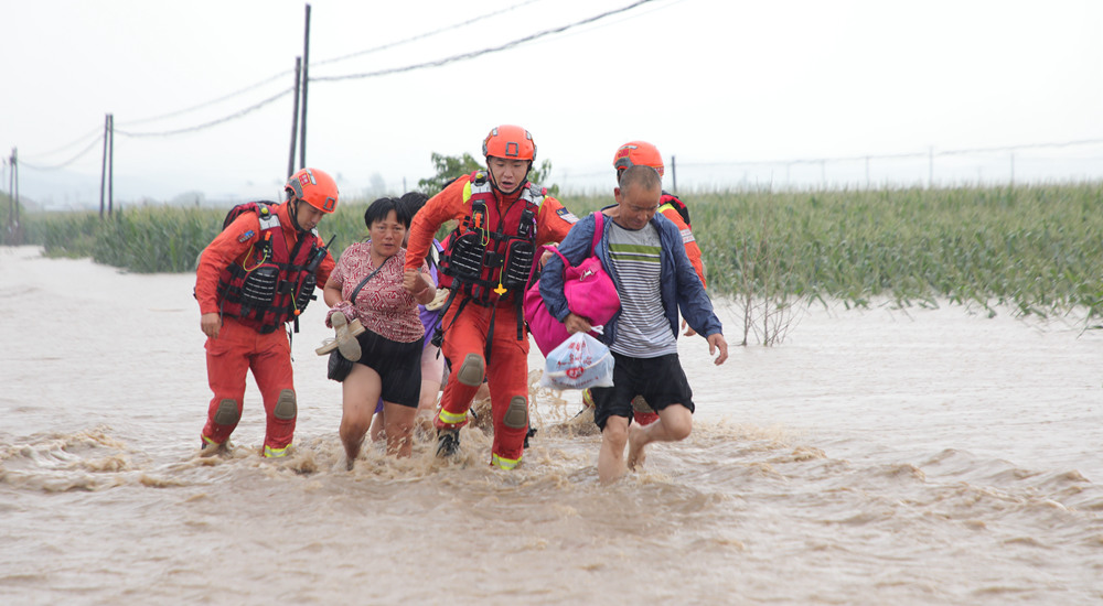 8月4日，吉林省吉林市森林消防支队的消防救援人员在舒兰市七里乡转移受灾群众。刘以晴 薛二涛摄影报道