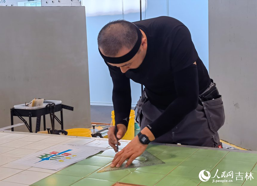 室內裝飾設計賽項選手寇文博正在瓷磚上劃線。人民網記者 馬俊華攝