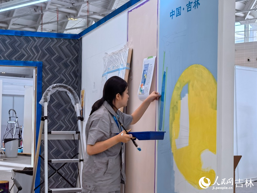 油漆與裝飾賽項選手龍彥池繪制牆面。人民網記者 馬俊華攝