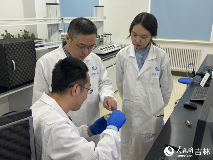 刘伟（左二）正在实验室指导团队成员。人民网记者 李思玥摄