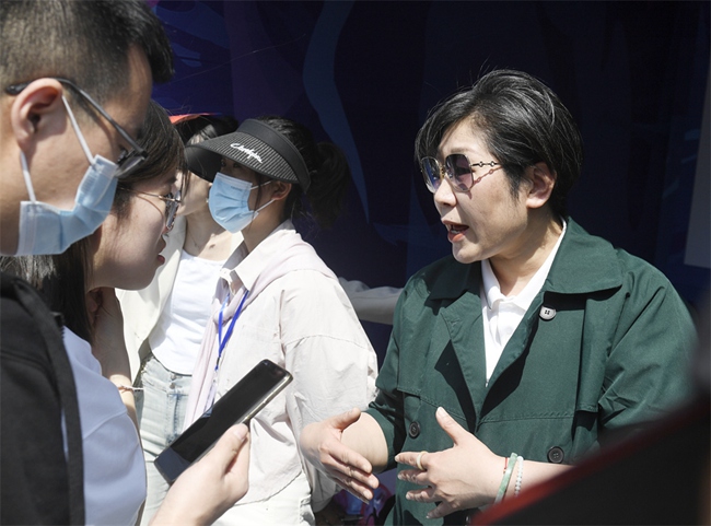 用人單位工作人員向求職大學生詳細介紹企業相關情況。