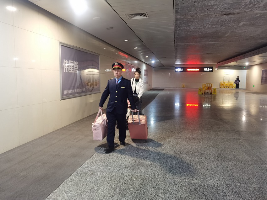 长春车务段德惠西站爱心服务团队成员帮助旅客搬运行李。汤明瑞摄