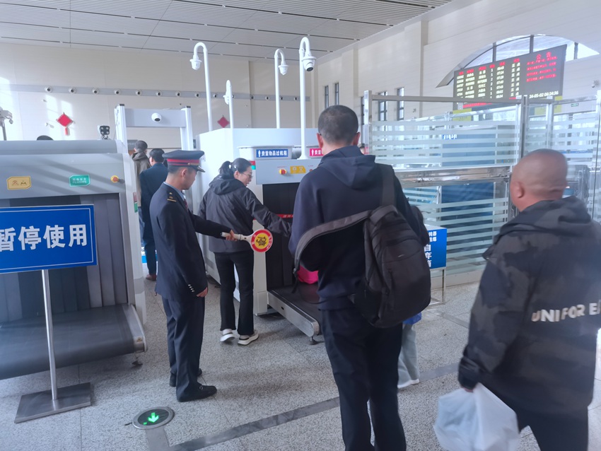 长春车务段德惠西站爱心服务团队成员吴德生休班时间引导旅客安检。汤明瑞摄