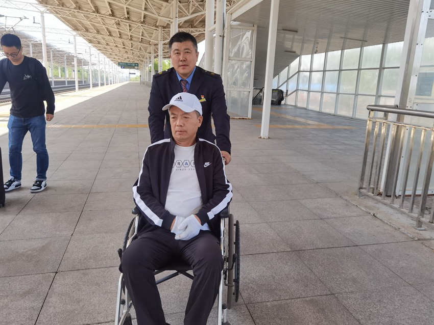 德惠西站客运员徐彦恒送重点旅客进站上车。汤明瑞摄