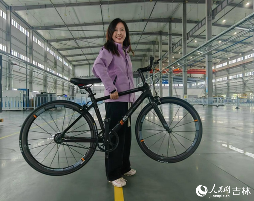 由碳纤维材质制作而成的自行车，重量轻到一只手就可以轻松拎起。人民网 石天蛟摄