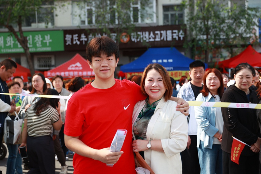 妈妈身穿旗袍为儿子加油。李军广  摄