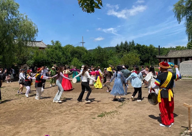游客与白龙村村民一同唱歌跳舞。