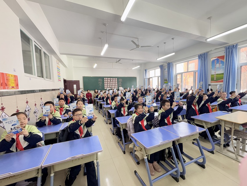 四平市第三中学附属小学学生们收到《尊法守法，平安一生》宣传手册。