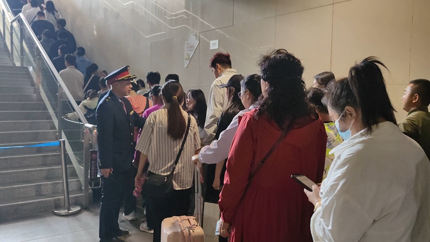 长春车务段公主岭南站客运值班员李晓咣组织旅客有序乘坐扶梯出站。冯凯摄