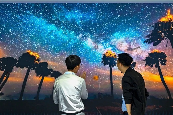 長春光博會希達電子展區，一位工作人員正在給一位觀眾講解。（長春新區供圖）