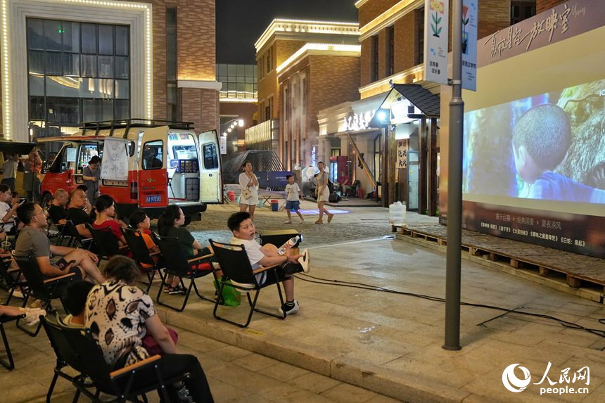 游客在春京西文旅街区观看露天电影。人民网记者 李洋摄