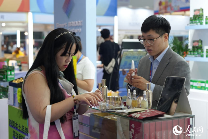 一名游客在第十五届中国—东北亚博览会上试用韩国化妆品。人民网记者 李洋摄