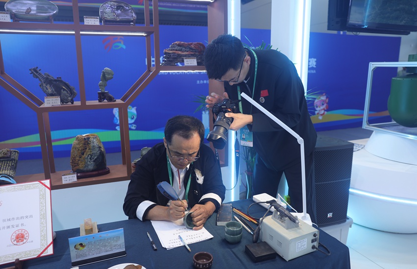 吉林省工艺美术大师、省级非遗传承人窦茂忠认真雕刻着手中的松花石。不一会儿工夫,一个个精美的字组成极具韵味的词句,跃然“石”上。杨宜修摄