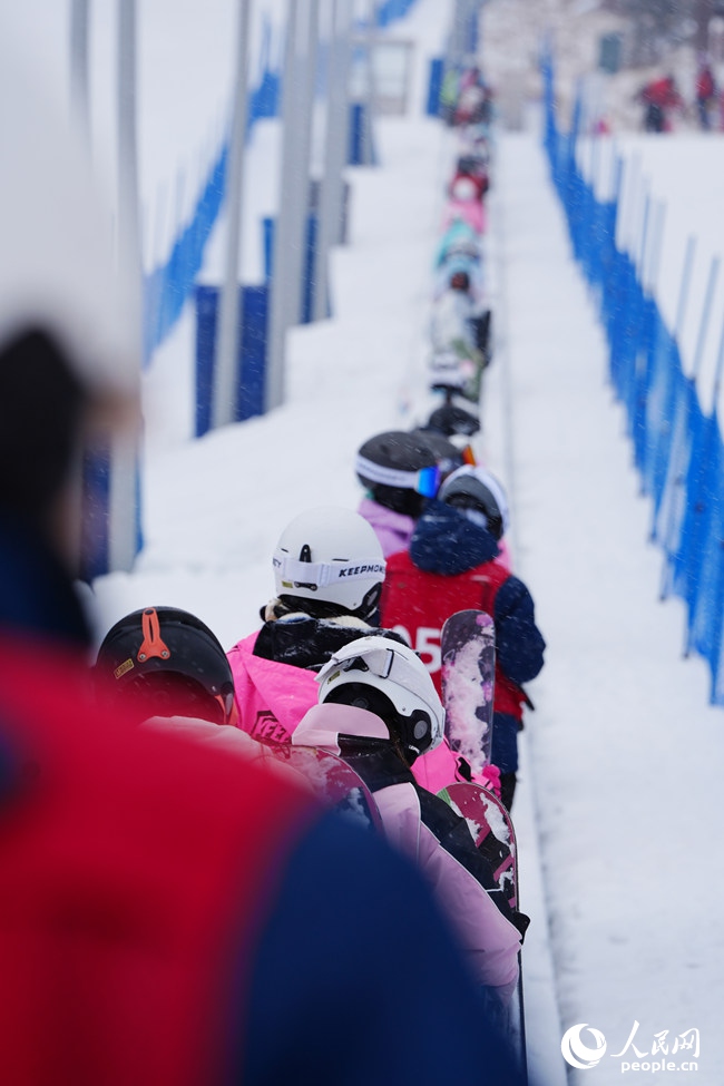 11月27日,滑雪爱好者在长白山和平滑雪场依次排队进入魔毯。人民网记者 李洋摄