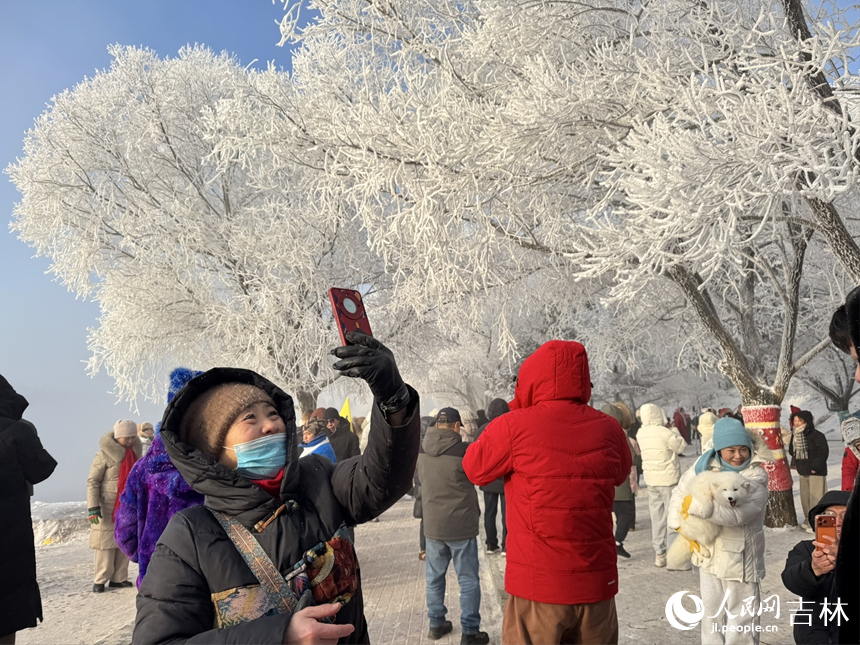 游客舉起手機，將冬日的美景定格在鏡頭中。人民網記者 李思玥攝