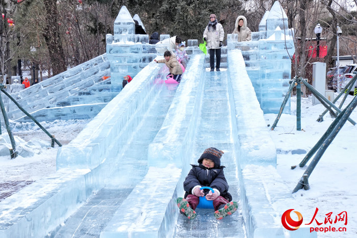 一位小朋友在新民大街旁的冰滑梯上暢享冰雪時光。人民網記者 李洋攝