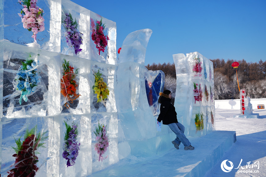 游客在长春净月潭国家森林公园与冰封墙合影留念。人民网记者 李洋摄