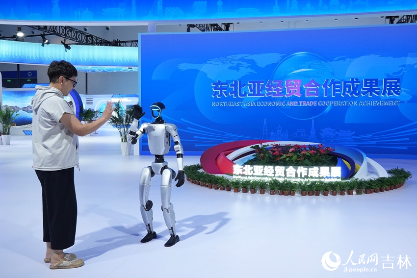 第十五届中国—东北亚博览会上，游客与机器人击掌。人民网记者 李洋摄