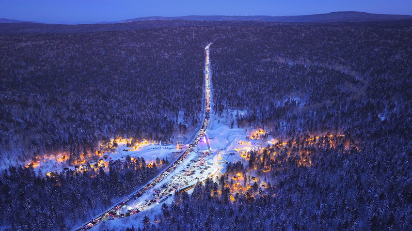 夜晚航拍鏡頭下，車流與燈光點亮林海。（和龍市委宣傳部供圖）