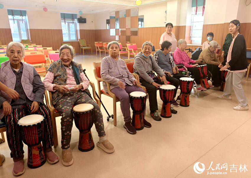 亲亲园养老护理康复中心，老人坐在一起学敲鼓。人民网记者 关思聪摄