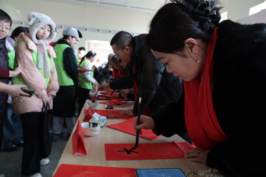 春运首日长春车务段德惠西站候车室内开展新春送福活动。孙宏昊摄