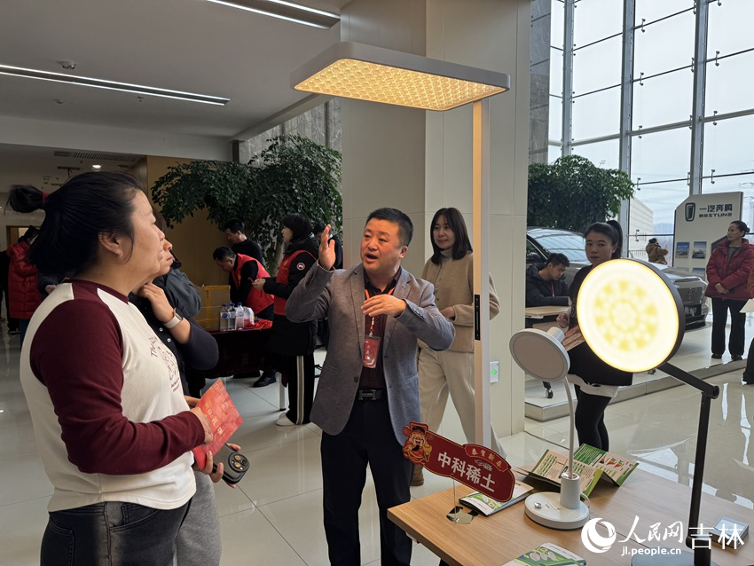中科稀土(长春)有限责任公司的展位前,销售总监王鸿宇为市民介绍护眼灯与普通光源的光谱差异。人民网记者 李思玥摄