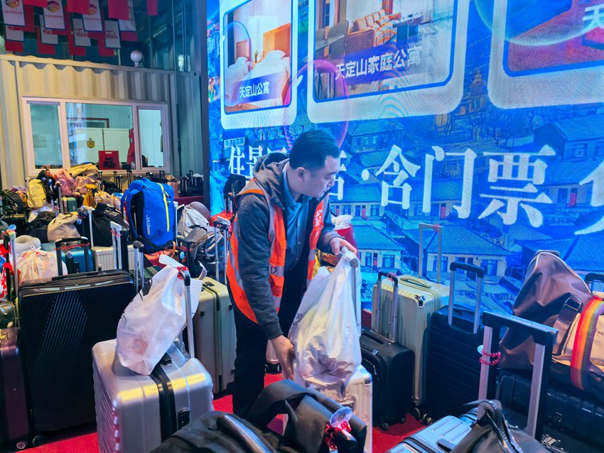 王国光将游客行李整齐摆放。人民网记者 王海跃摄