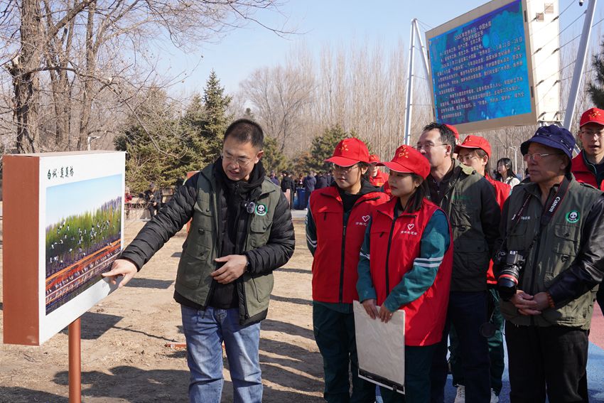 中动协白城护飞队志愿者在摄影展现场讲解生态摄影作品