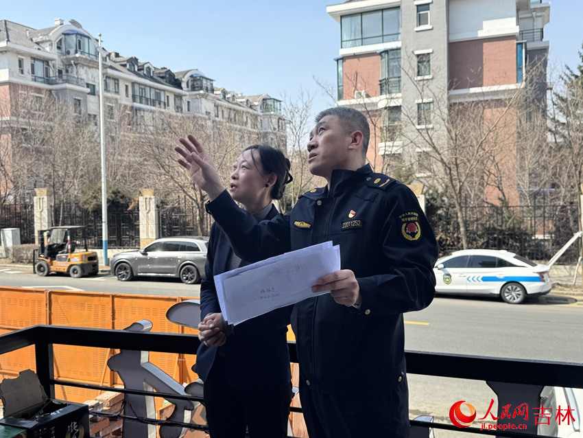 朝阳区城市管理行政执法局工作人员正上门为商户讲解牌匾安装注意事项。人民网记者 李思玥摄