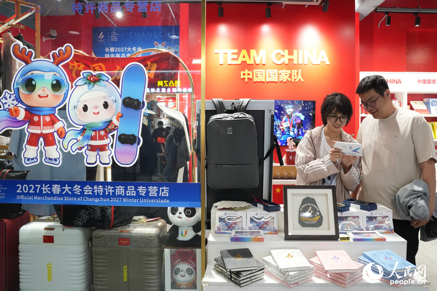 两名青年在2027长春大冬会特许商品店挑选喜爱的文创产品。人民网记者 李洋摄
