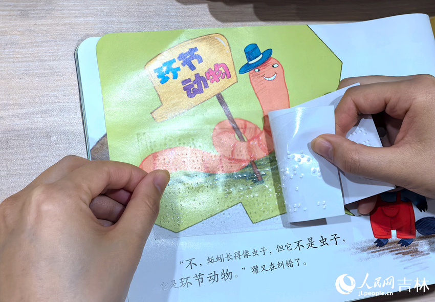 志願者在繪本上貼盲文。人民網記者 王海躍攝