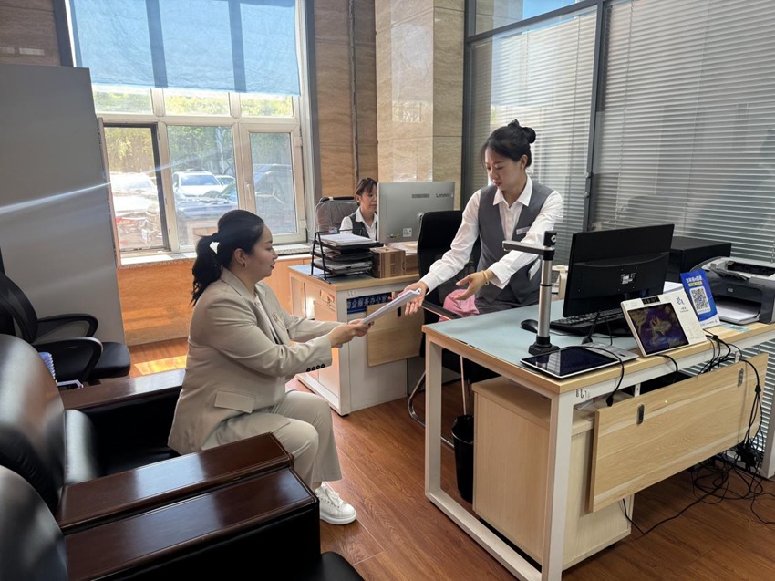 在朝阳区政务服务中心助企服务办公室内，长白山宾馆总经理倪赛娇正在咨询相关业务。
