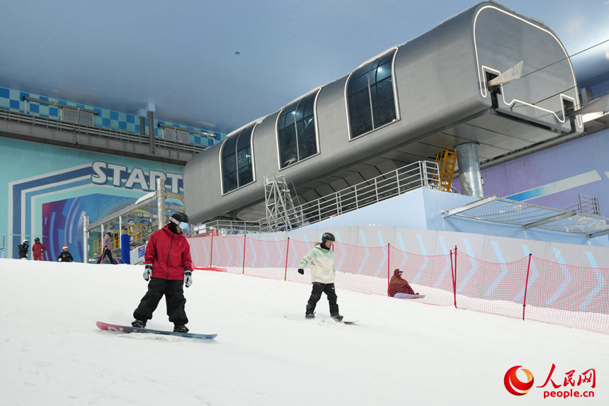 滑雪爱好者在滑雪场“山顶”一跃而下。人民网记者 李洋摄