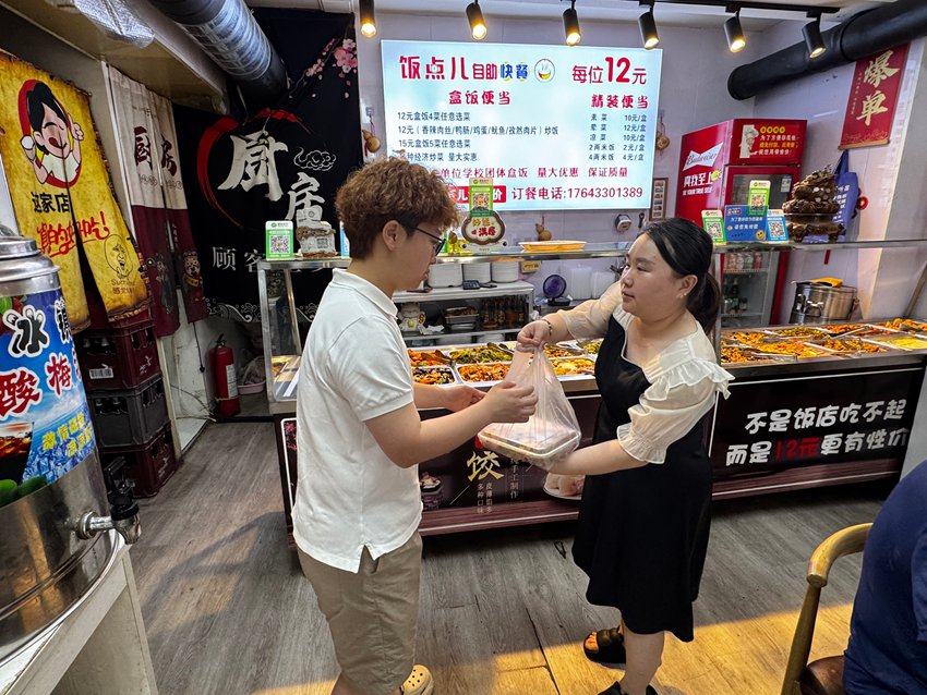 工作人员到爱心商户取餐