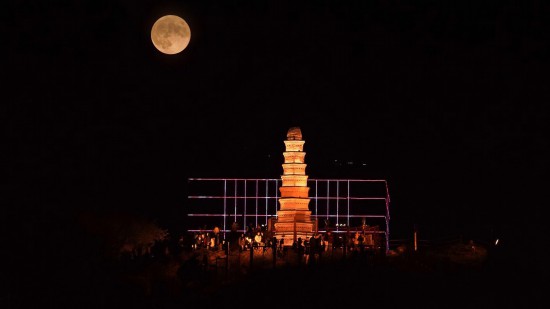 9月29日晚，中秋圓月升起，與新疆烏魯木齊地標建筑紅山塔重疊（二次曝光）。人民網 李欣洋攝