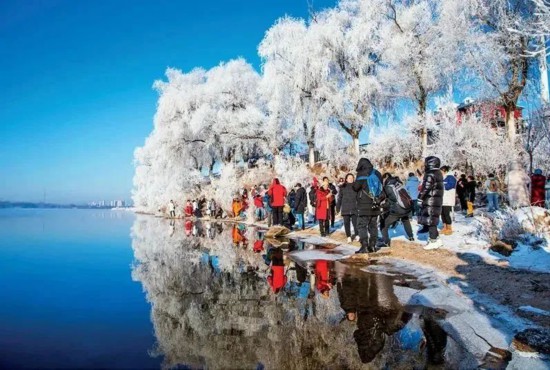 近年来，吉林省大力发展冰雪经济，做大做强冰雪产业，让“冰天雪地”真正成为“金山银山”。图为2023年12月1日，“北国江城”吉林省吉林市松花江畔小雾凇岛，又迎来一场雾凇盛观，吸引众多游客前往观赏。中新社发 仲雁铭/摄