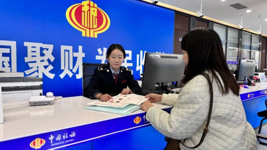 在市政务服务中心综合受理服务区，税务人员为经营者讲解办理流程