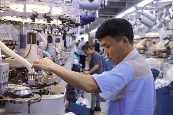 在辽源“親相见”袜业工厂织造区，工人正忙碌着